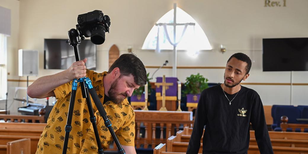 Stefan Woehlke and student holding a camera in church