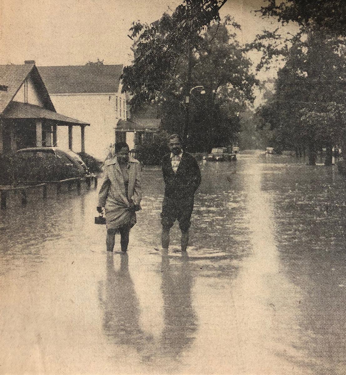 Print magazine image of a couple walking through flooded streets of North Brentwood, Md. in 1955.